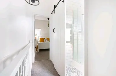 a white bathroom with a shower and a mirror at The Cwtch in Brecon