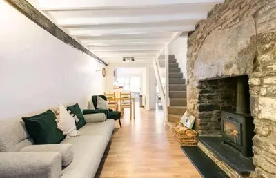 a living room with a couch and a stone fireplace at The Cwtch in Brecon