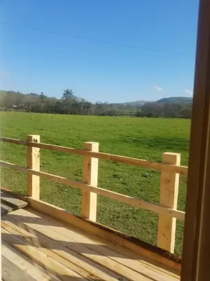 a fence in front of a green field at Rhydydefaid Cwt Clyd - Cosy Hut in Bala