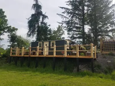a tiny house on a wooden bridge in a field at Rhydydefaid Cwt Clyd - Cosy Hut in Bala