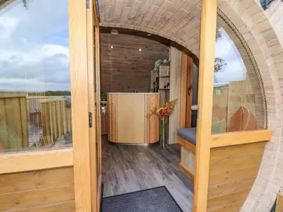 an open door to a room with a vase of flowers at Tan Y Wawr - Derwen in Welshpool
