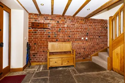 a room with a brick wall and a wooden bench at The Agents House, Bed & Breakfast in Hay-on-Wye