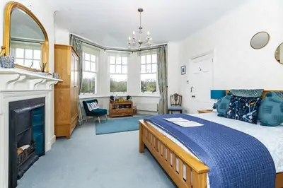 a bedroom with a large bed and a fireplace at The Agents House, Bed & Breakfast in Hay-on-Wye