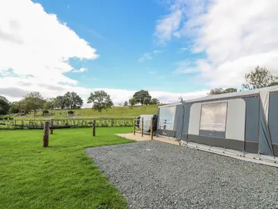 a caravan parked in a field next to a grass field at The Salmon in Rhayader