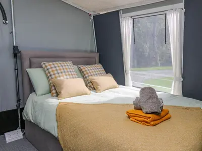 a bedroom with a large bed with a window at The Heron in Rhayader
