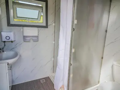 a bathroom with a shower and a sink and a mirror at The Heron in Rhayader