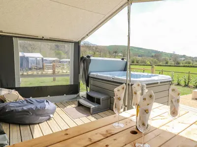 a gazebo with a hot tub and a deck at The Heron in Rhayader