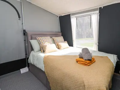 a bedroom with a large bed with a window at The Kingfisher in Rhayader