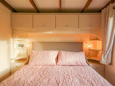 a bed in a room with cabinets and a bedspread at Riverside Rest in Builth Wells