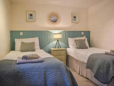 a bedroom with two beds and a mirror at Ysgubor Blaenparc Barn - Uk41030 in Mydroilin