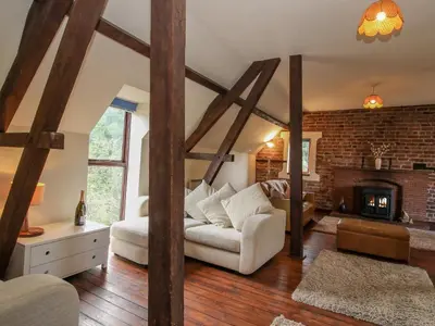 a living room with a couch and a fireplace at Owlbury Hall Barn in Montgomery