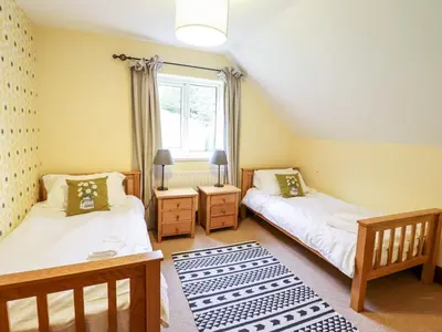 two twin beds in a room with a window at Gwengraig in Dolgellau