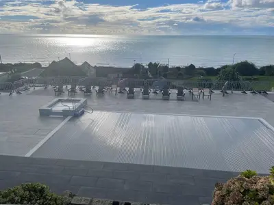 a parking lot with benches and the ocean in the background at Barmouth Pet-Friendly 2-Bed Caravan with Sea View in Barmouth