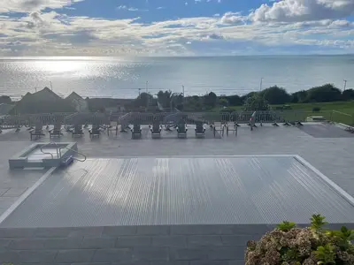 a row of benches in a parking lot near the water at Barmouth Pet-Friendly 2-Bed Caravan with Sea View in Barmouth
