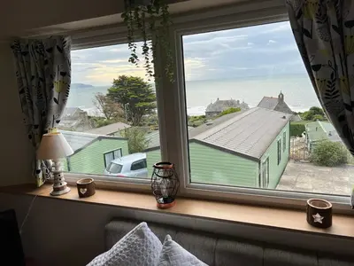a bedroom window with a view of the ocean at Barmouth Pet-Friendly 2-Bed Caravan with Sea View in Barmouth