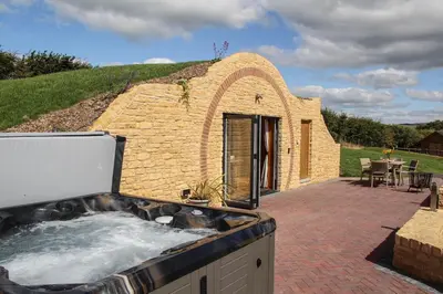 a small brick building with a hot tub at Burrow View in Rhayader