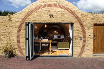 a brick house with an archway with a table in it at Burrow View in Rhayader