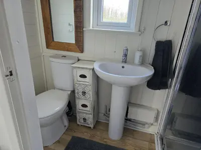 a small bathroom with a sink and a toilet at Glamping Hut - Sleeps 2 hot tub & parking in Welshpool