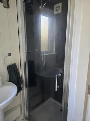 a bathroom with a shower with a sink and a toilet at Glamping Hut - Sleeps 2 hot tub & parking in Welshpool