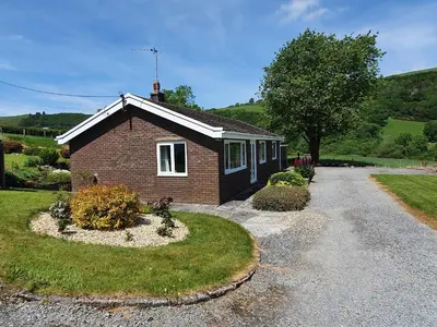 a small brick house on a gravel road at Llwynon in Aberystwyth