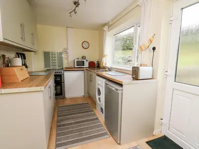 a kitchen with white appliances and a window at Llwynon in Aberystwyth