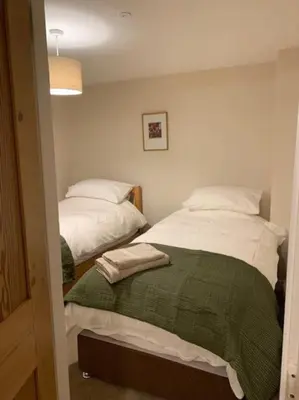 a bedroom with two beds with towels on them at Cwmbach Cottage, Hay on Wye in Glasbury