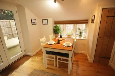 a dining room with a wooden table and chairs at Cwmbach Cottage, Hay on Wye in Glasbury