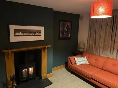 a living room with a couch and a fireplace at Cwmbach Cottage, Hay on Wye in Glasbury
