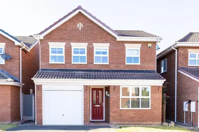 a red brick house with a white garage at Fair View - Off Street Parking and Garden in Shrewsbury