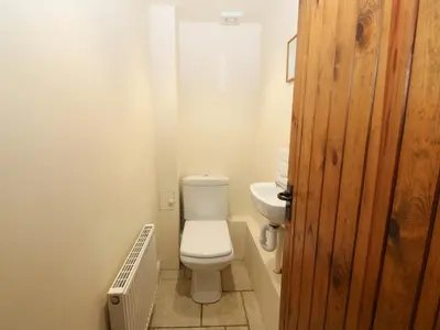 a bathroom with a white toilet and a sink at Tyn Llwyn in Talsarnau