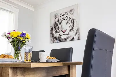 a dining room table with a tiger picture on the wall at Fair Haven - Off Street Parking and Garden in Shrewsbury
