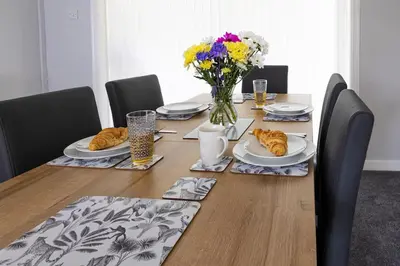 a table with plates of food and a vase of flowers at Fair Haven - Off Street Parking and Garden in Shrewsbury