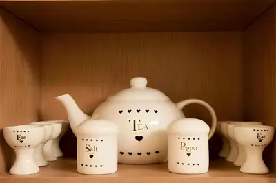a shelf with a teapot and four differentiatesiatesiatesiatesiatesiates at Pet-Friendly Logburner Horse Stable Views in Hay-on-Wye