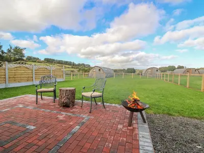 two chairs and a fire pit in a backyard at Poppy in Rhayader