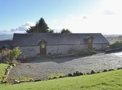 a house with a gravel driveway in front of it at Stable Cottage in Oswestry