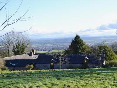 a house on a hill in a field at Stable Cottage in Oswestry