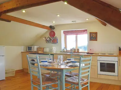 a kitchen with a table and chairs in a kitchen at Stable Cottage in Oswestry