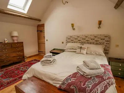 a bedroom with a large bed with towels on it at Pen Bont Home Farm in Brecon