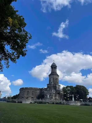 an old building with a tower on top of a field at Chandeliers 6 in Shrewsbury