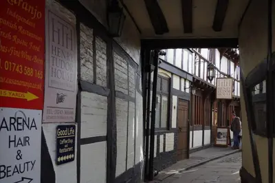 an alley with signs on the side of a building at Chandeliers 6 in Shrewsbury