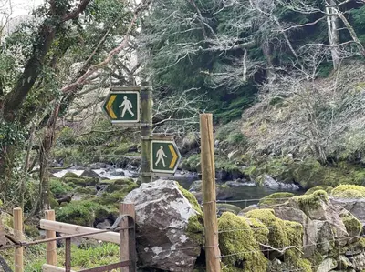 a sign on a rock next to a river at Charming Riverside Cottage in Snowdonia National Park in Tanygrisiau
