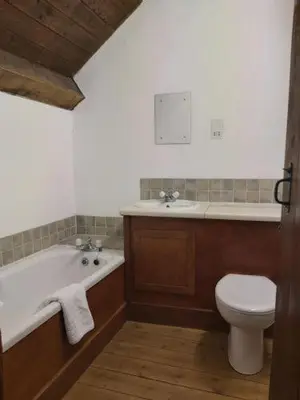 a bathroom with a tub and a toilet and a sink at Longhouse - Y Beudy in Rhayader