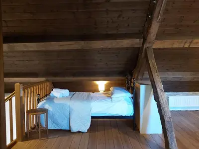 a bedroom with a bed in a wooden attic at Longhouse - Y Beudy in Rhayader