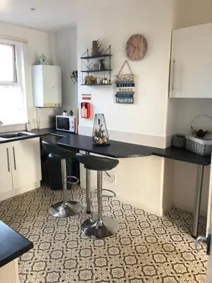 a kitchen with a black counter top in a room at Tywyn seaside apartment with Mountain View in Tywyn