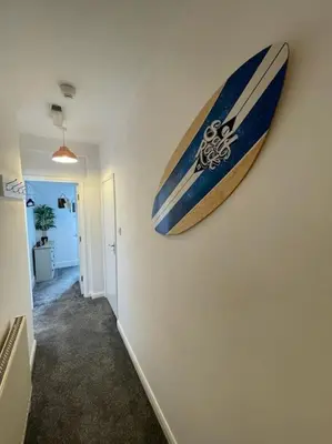 a surfboard hanging on a wall in a hallway at Tywyn seaside apartment with Mountain View in Tywyn