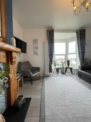 a living room with a couch and a table at Tywyn seaside apartment with Mountain View in Tywyn