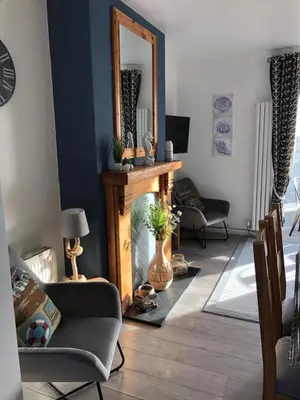 a living room with a fireplace and a mirror at Tywyn seaside apartment with Mountain View in Tywyn