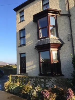 a house with a window on the side of it at Tywyn seaside apartment with Mountain View in Tywyn