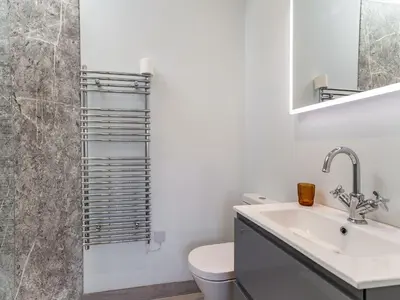 a white bathroom with a toilet and a sink at Dau Ddeg in New Quay