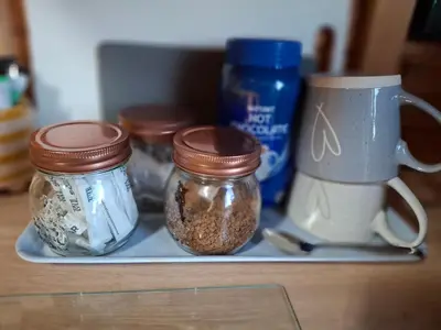a shelf with jars of food and a coffee mug at The Hut B & B in Mochdre